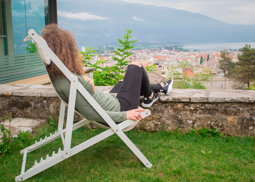 mujer descansando en su terraza sentada en una tumbona